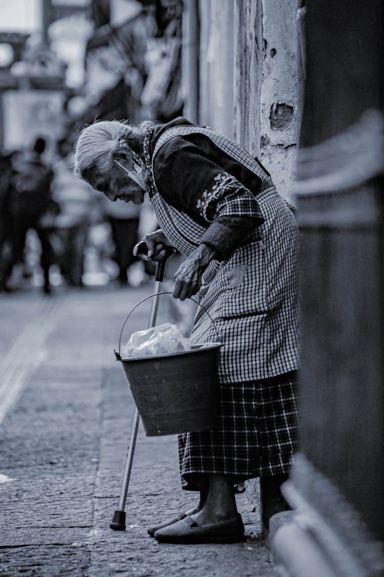 Elderly Woman Carrying Bucket