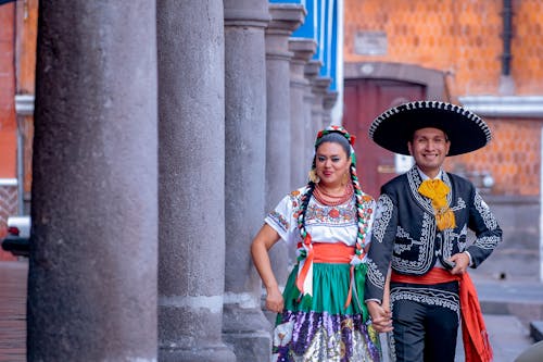 Couple in Traditional Mexican Clothes Walking Along the Colonnade