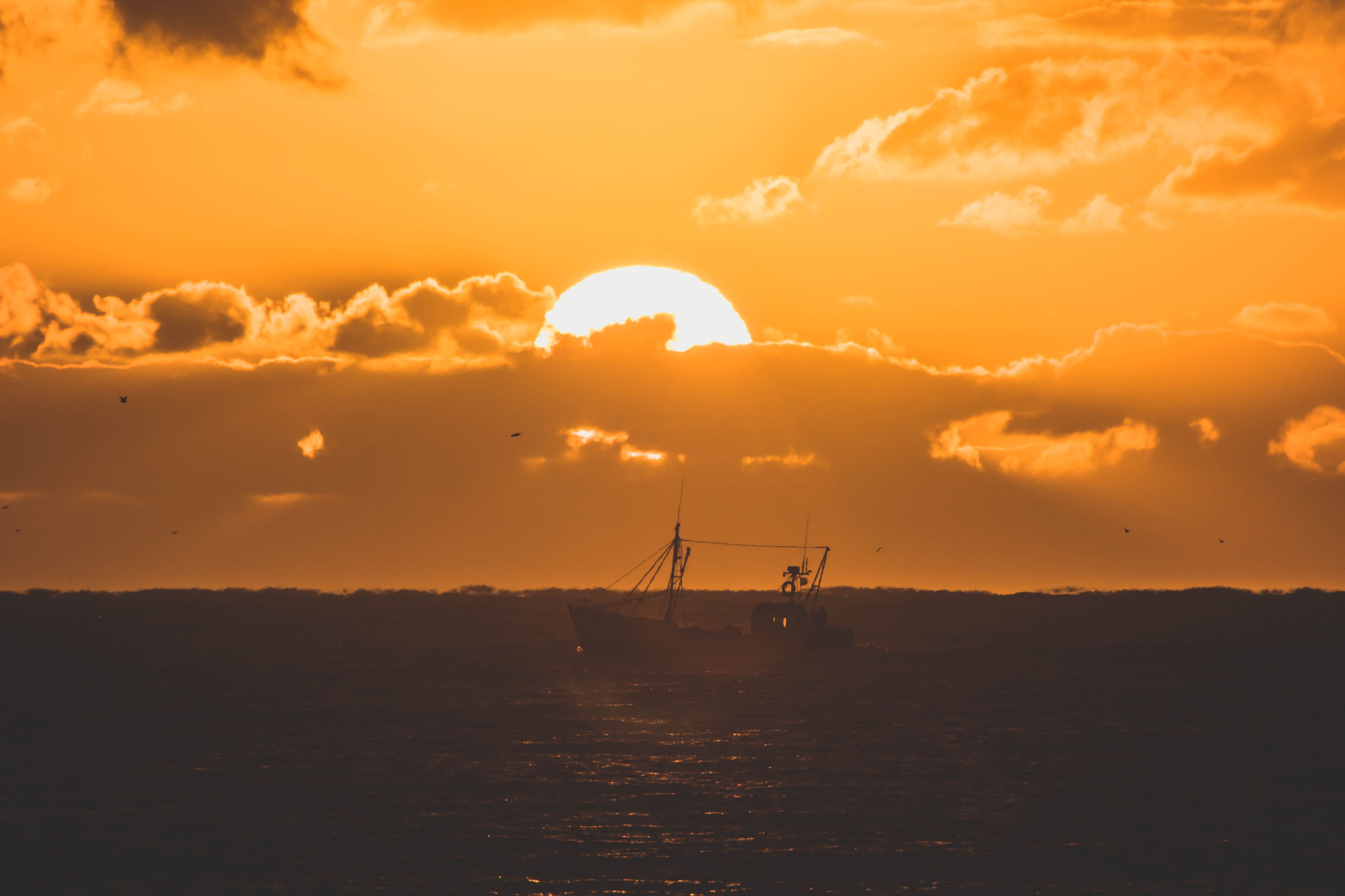 A Boat on the Sea During Sunset · Free Stock Photo