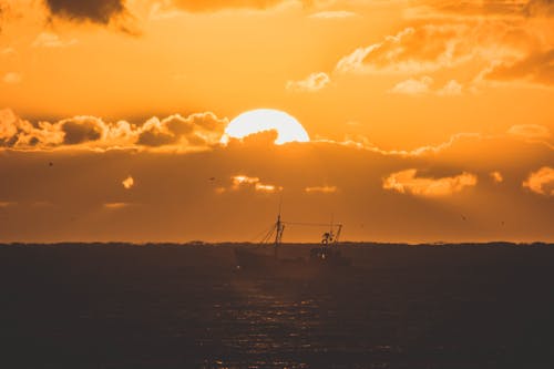 A Boat on the Sea During Sunset 