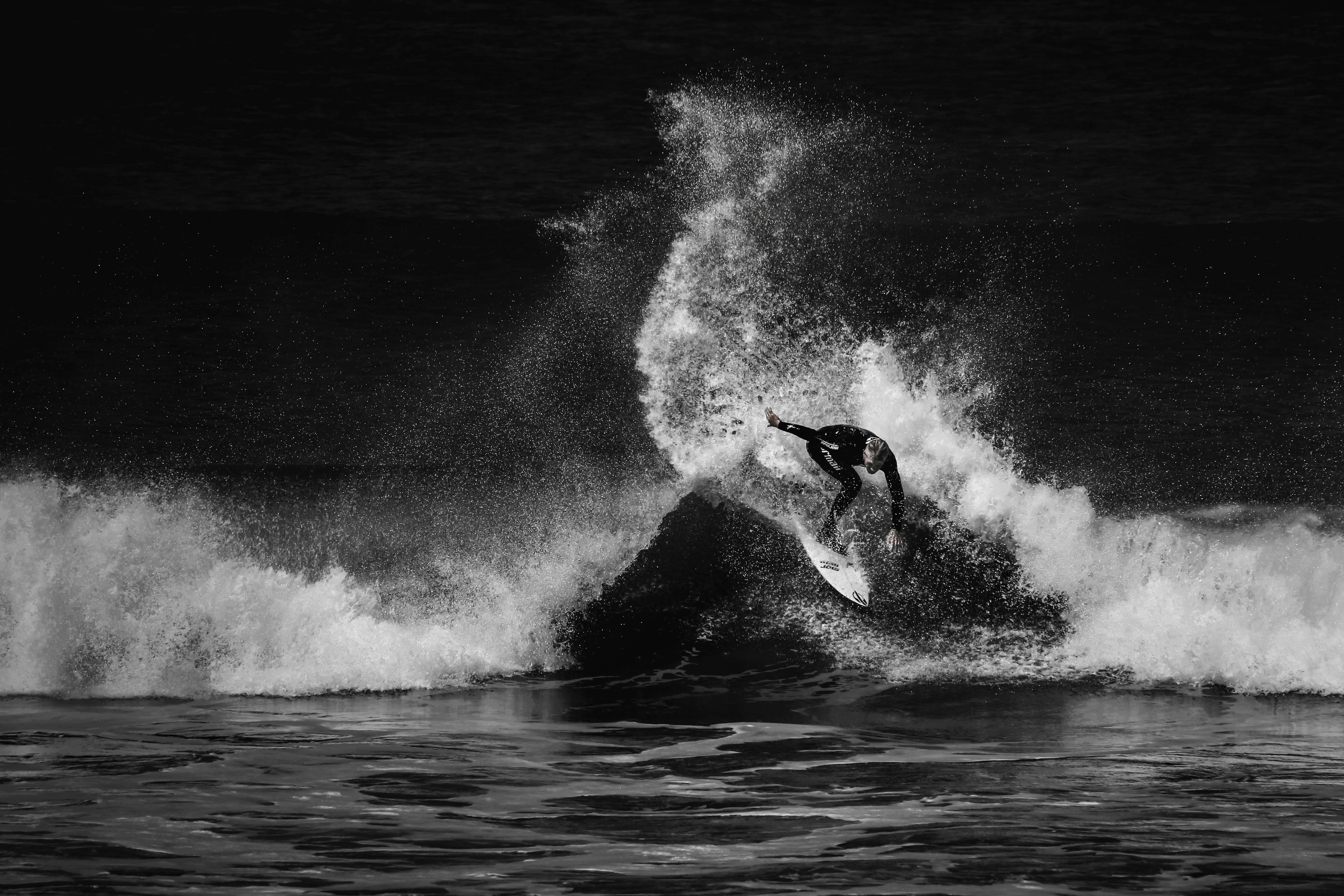 Captivating black and white photo of a surfer maneuvering through a powerful ocean wave.