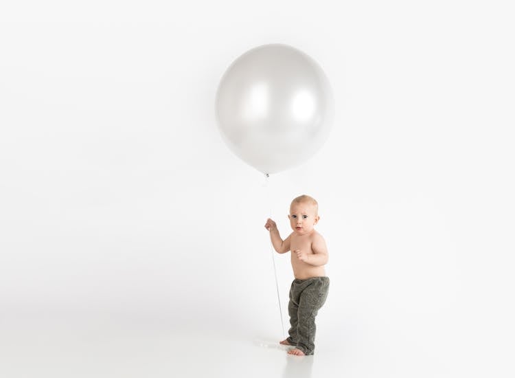 Baby Holding White Balloon