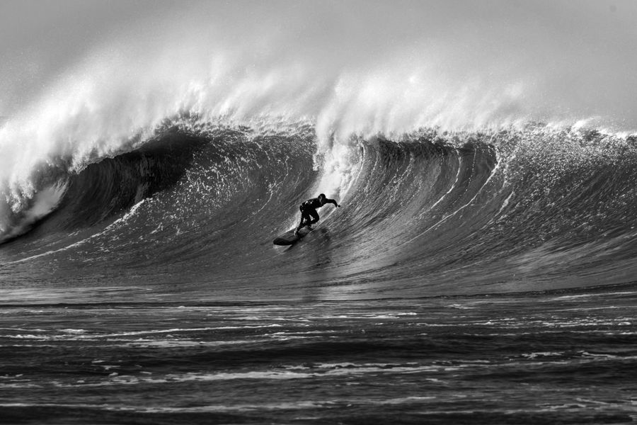 Black and white photograph of a surfer on a large wave