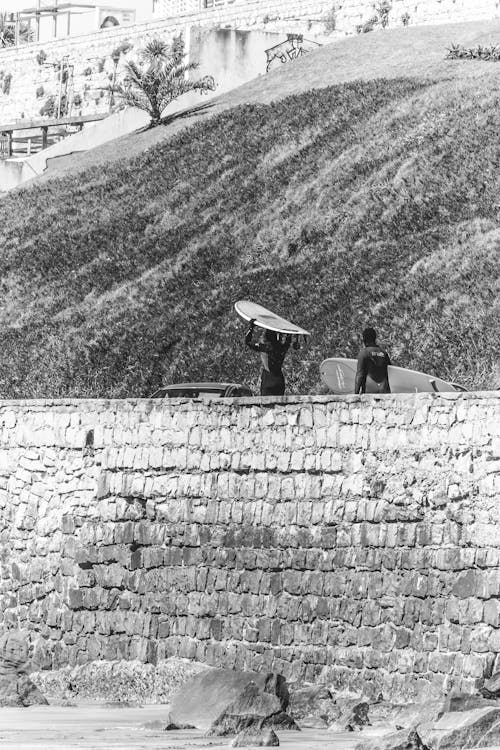 Surfers Carrying Their Surfboards