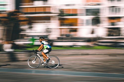 Free A cyclist rides a road bike swiftly in İzmir with motion blur, showcasing speed and agility. Stock Photo
