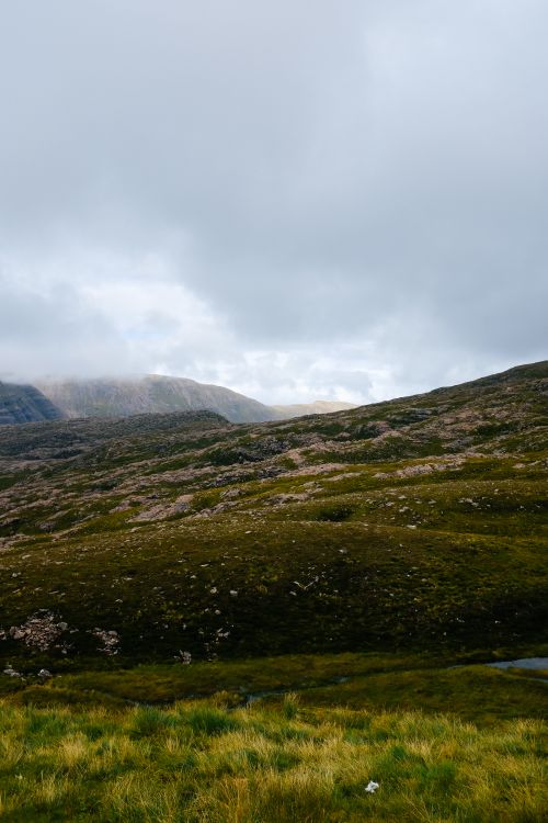 Free Expansive mountain landscape with rocky formations beneath a cloudy sky. Stock Photo