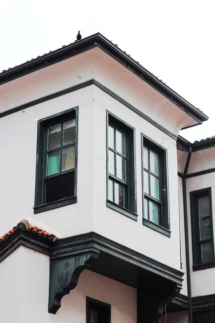 Close-up of a modern building facade featuring glass windows and architectural details.