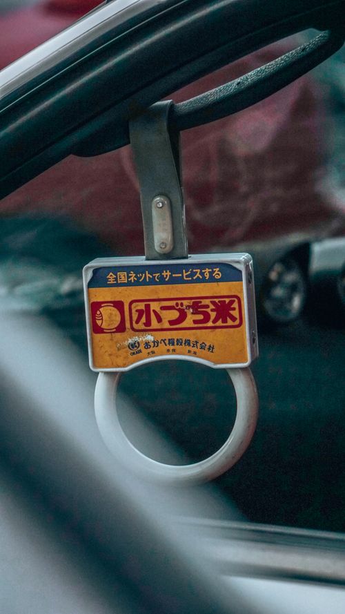 Free Detailed view of a train handle featuring Japanese advertisements, evoking a sense of public transportation. Stock Photo