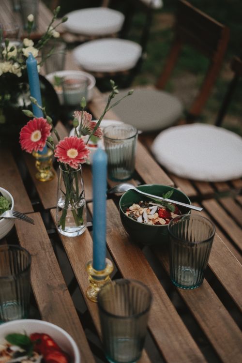 Free Beautifully decorated outdoor table with flowers, candles, and a fresh salad, perfect for gatherings. Stock Photo