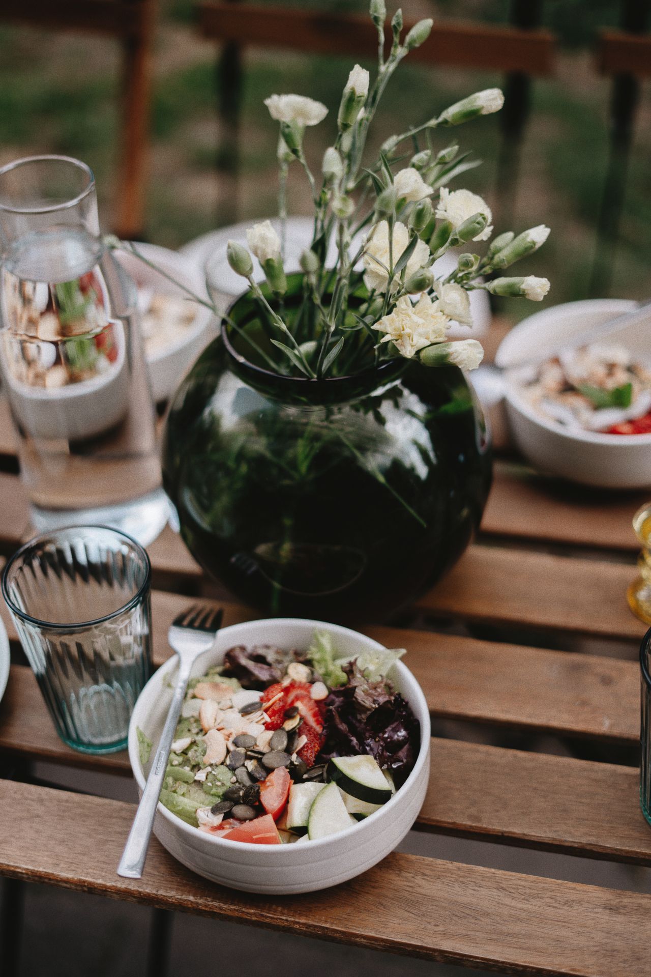 Semangkuk salad segar dengan sayuran hijau di atas meja kayu