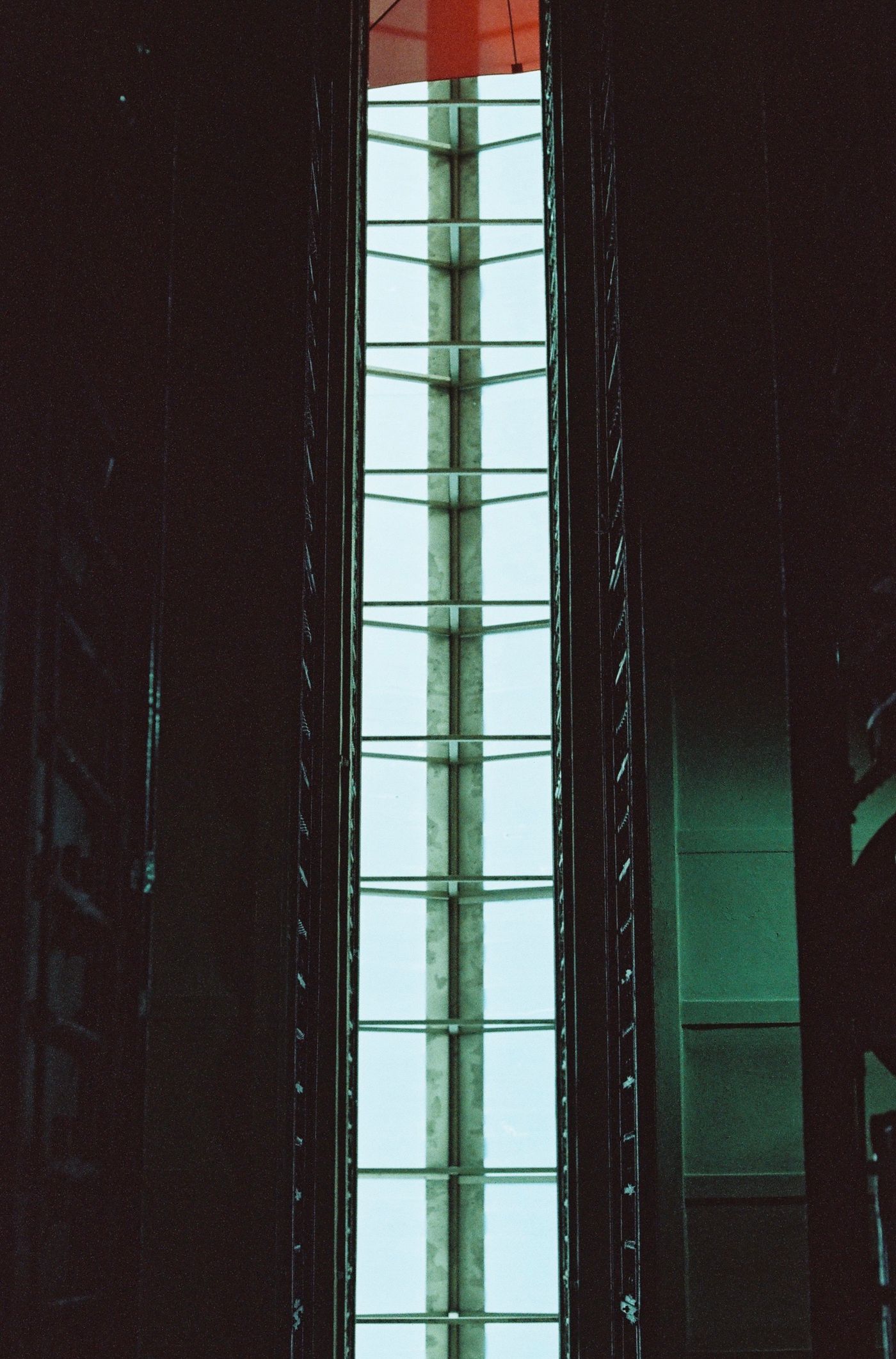 Illuminated glass elevator shaft and custom structural interface