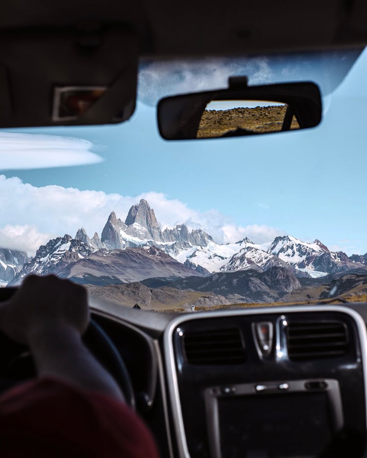 A Person Driving A Car With A View Of The Fitz Roy Mountain