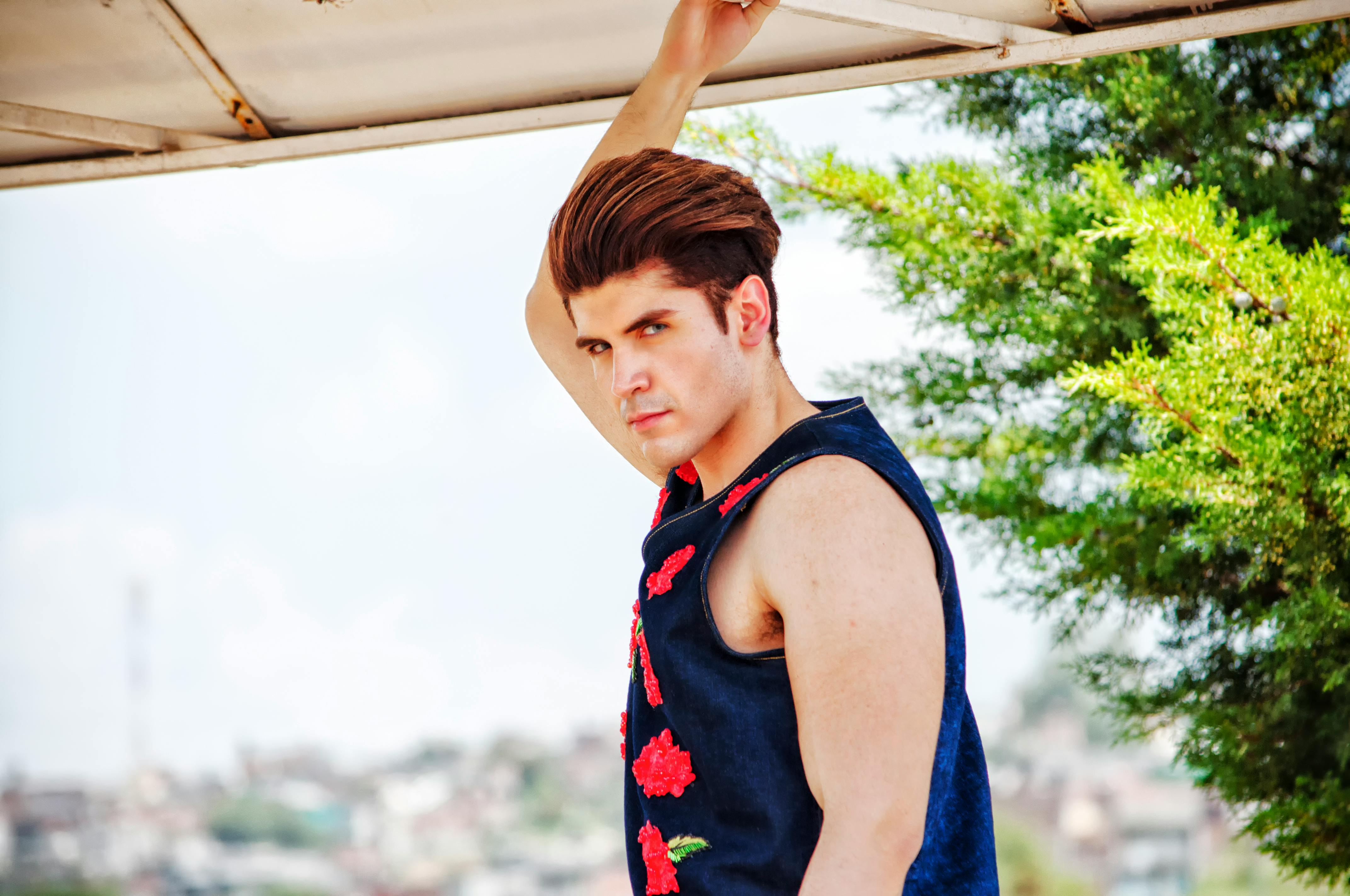 一位穿着刺绣背心的时尚男子，在莫雷利亚自信地摆出户外姿势