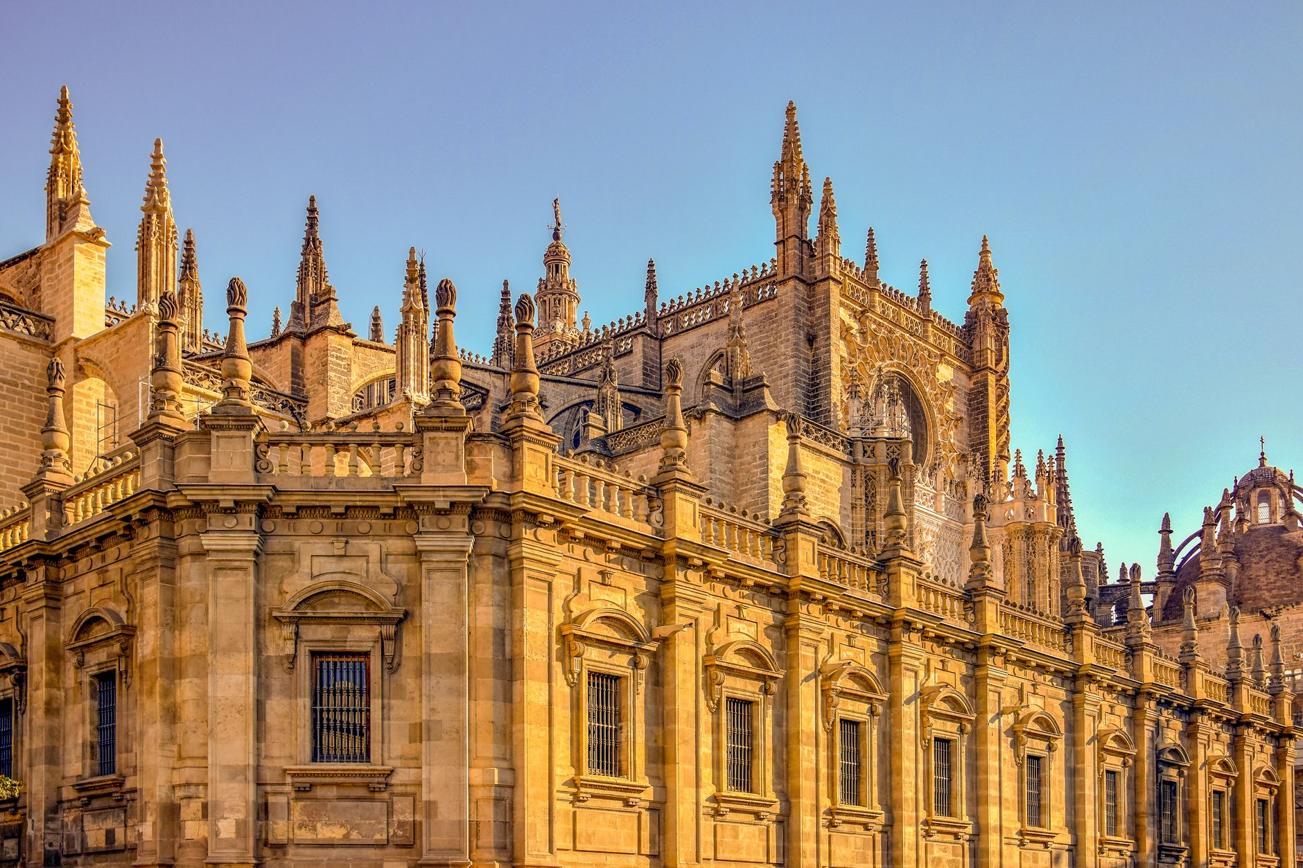 Majestic view of the Gothic Seville Cathedral facade in warm sunlight.