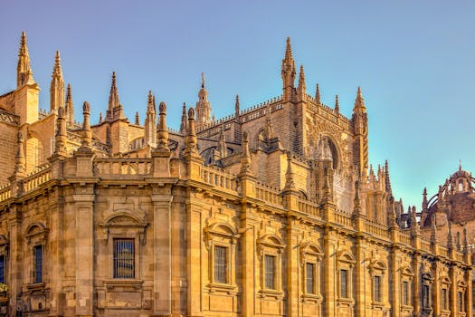 Majestic view of the Gothic Seville Cathedral facade in warm sunlight.