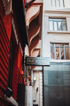 View of a Ruz Hotels sign in a narrow urban alley with architectural details.