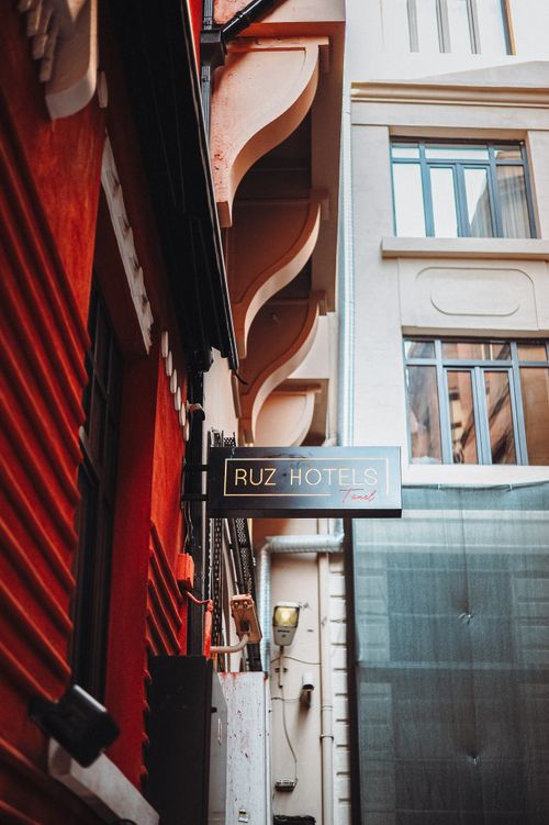 Free View of Ruz Hotels sign amidst architectural details in a narrow city alleyway. Stock Photo