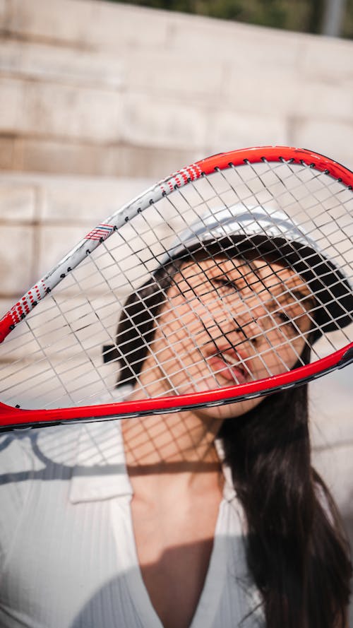 Woman Holding a Tennis Racket near Face