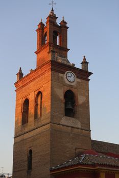 A stunning view of the clock tower at Iglesia de San Lorenzo in Sevilla, Spain during the day.
