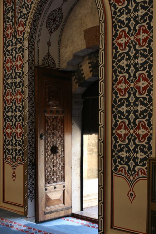 Free Wooden door set in a beautifully patterned archway, creating an artistic entrance. Stock Photo