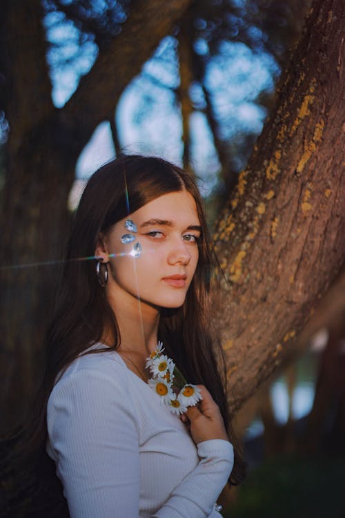Portrait of Woman with Crystals on Face Posing near Tree