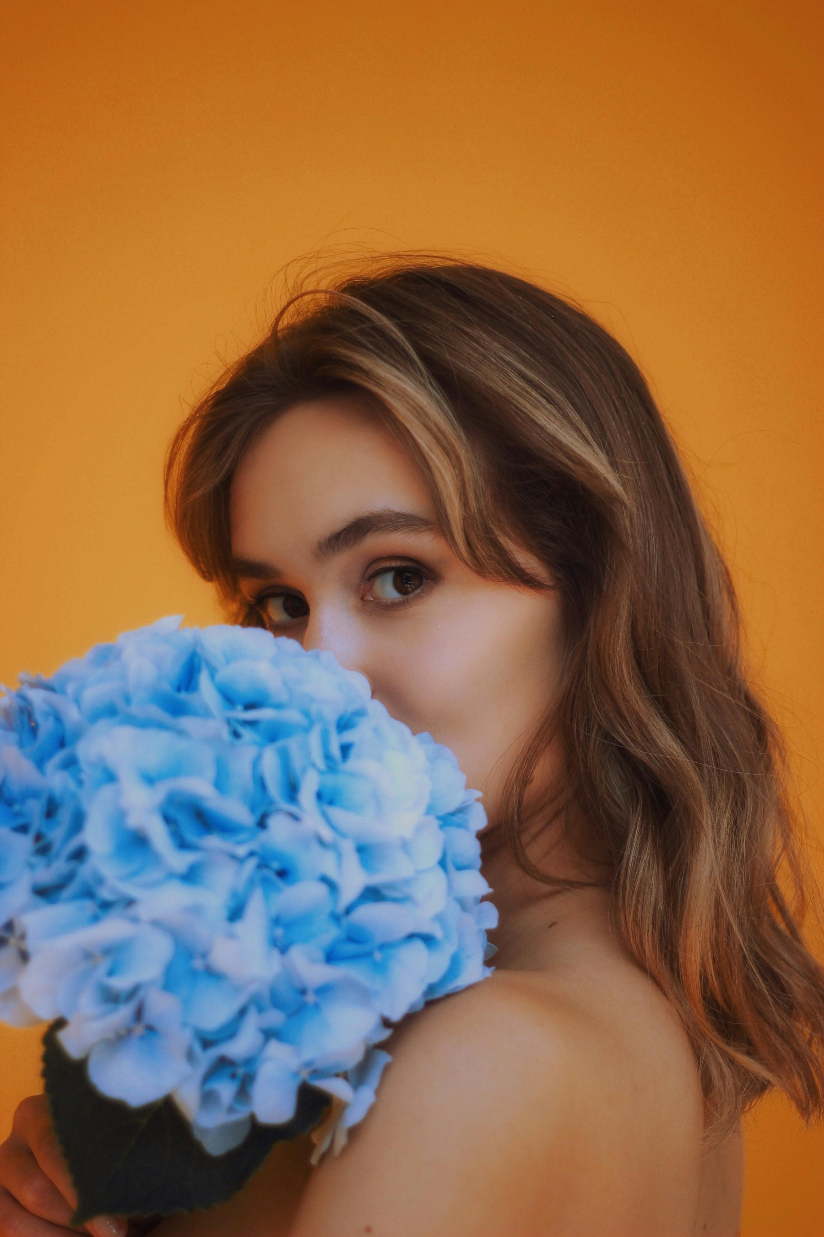 woman posing with bouquet on orange background