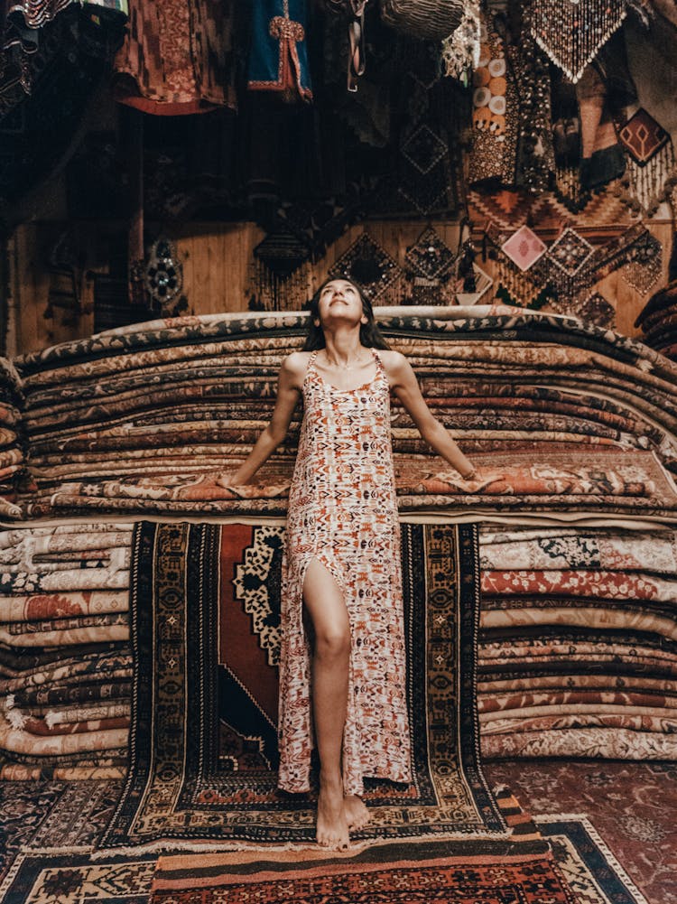 Woman In Dress Posing In Traditional Carpet Shop