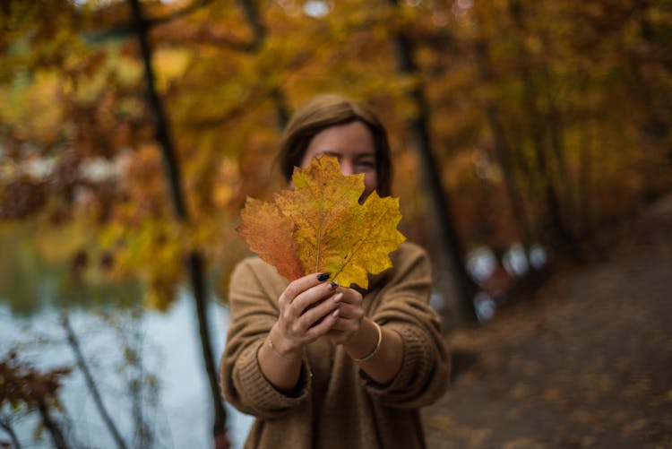 A Woman Holding A Maple Leaf