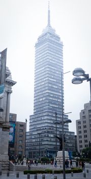 Vertical view of Torre Latinoamericana against cloudy sky in Mexico City.