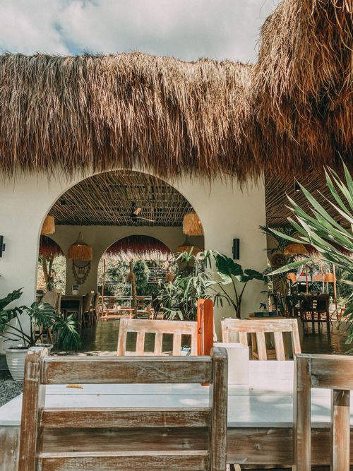 Free Explore a charming café in Indonesia featuring rustic wooden furniture and tropical plants. Stock Photo