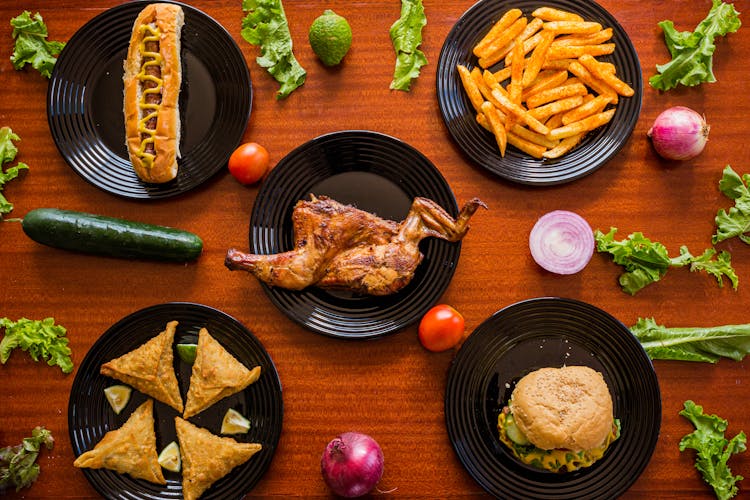 Variety Of Foods On Black Ceramic Plates