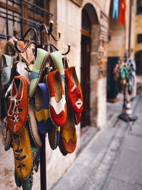 Assorted Children Leather Shoes Hanging on Wrought Iron Coat Rack