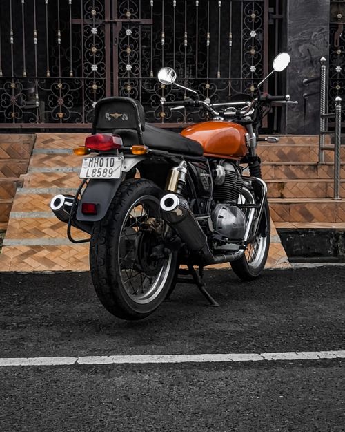 Free A vintage Royal Enfield motorcycle parked on a sidewalk with a classic design. Stock Photo