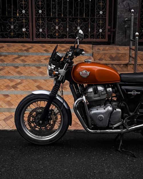Free A vintage Royal Enfield Interceptor 650 parked outdoors, showcasing its retro design and chrome details. Stock Photo