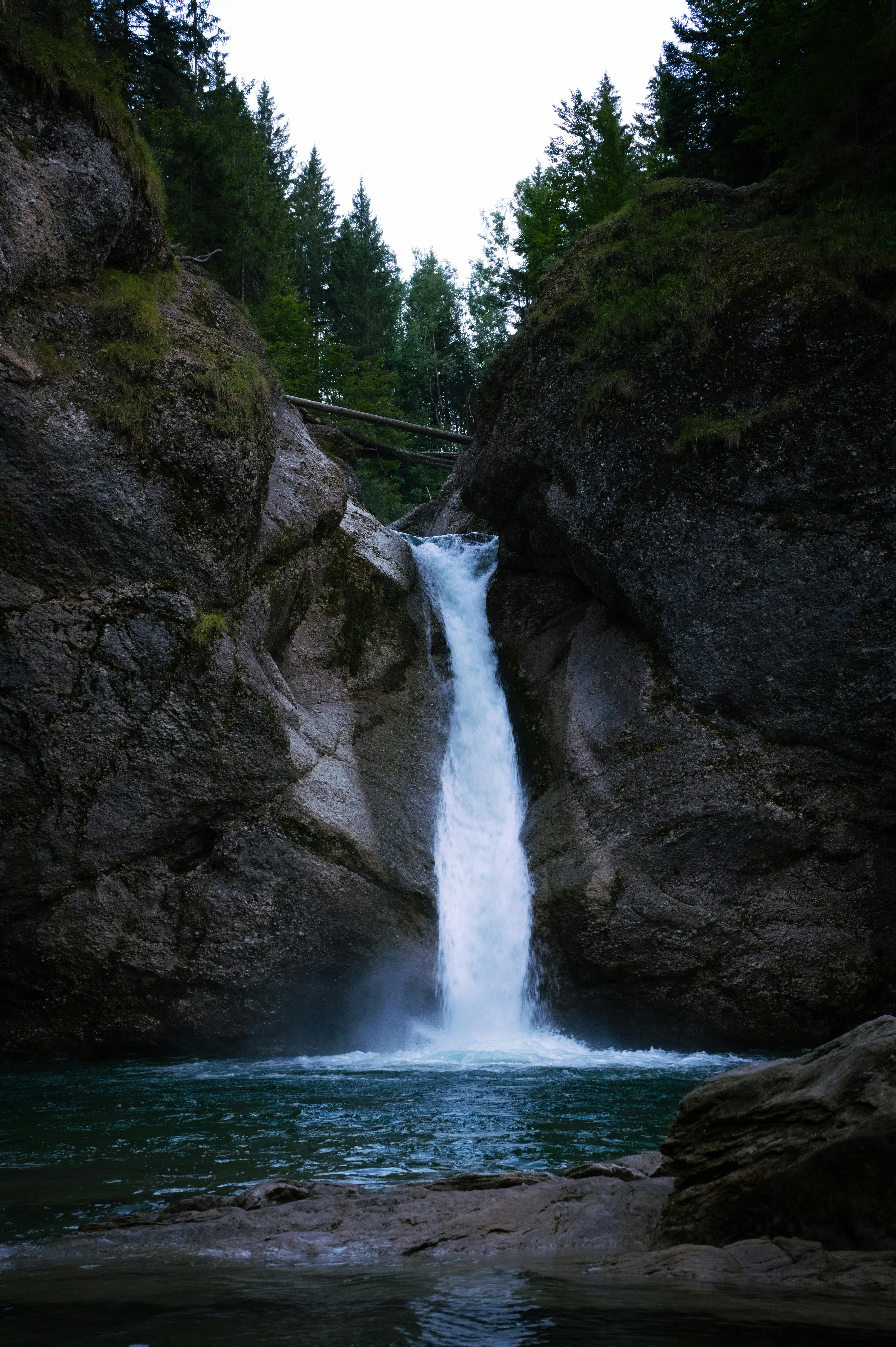 Stunning waterfall cascading through rocks surrounded by lush forest trees.