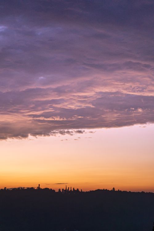 Free A breathtaking sunset in Srinagar featuring dramatic clouds and silhouetted trees, creating a picturesque scene. Stock Photo