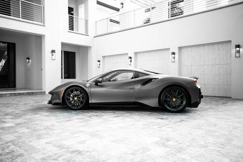 Free Grayscale image of a luxury sports car parked in a modern house courtyard. Stock Photo