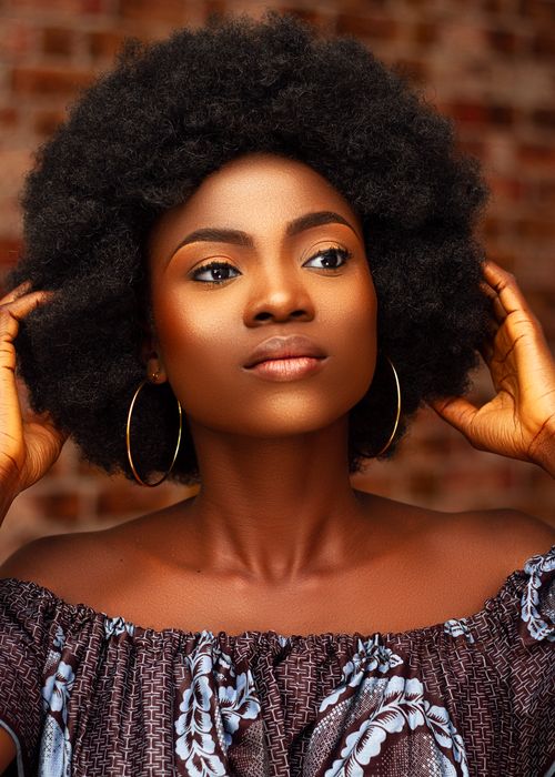 Free Close-up portrait of a beautiful young Nigerian woman with afro hair and hoop earrings. Stock Photo
