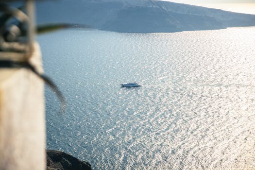 A serene high angle view of a boat sailing on calm ocean waters under the bright afternoon sun.