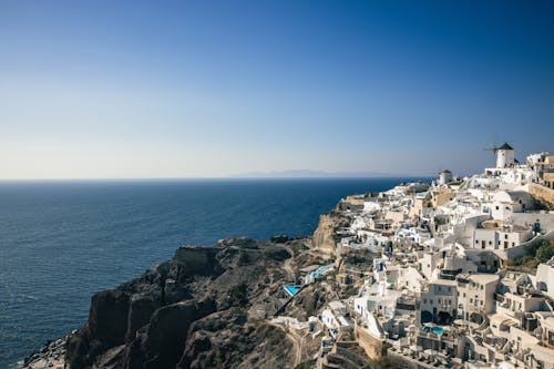 White Concrete Buildings Near Sea Under Blue Sky