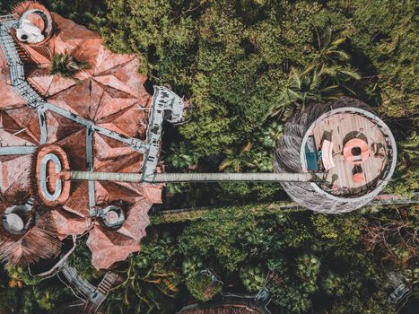 Stunning aerial photograph of a unique wooden treehouse resort nestled in a lush green forest.