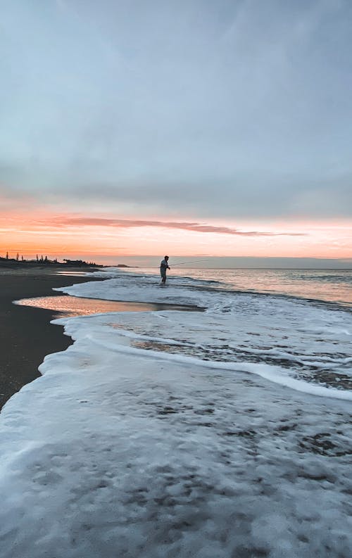 Landscape Photography of a Person Fishing at a Beach