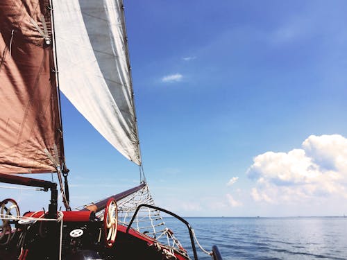 Vela Blanca Y Marrón En Barco En Cuerpo De Agua