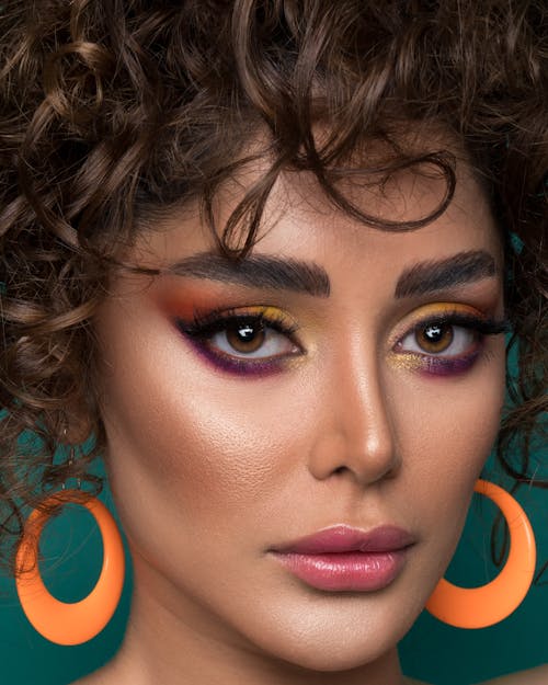 Woman With Pink Lipstick and Eye Makeup Wearing Orange Hoop Earrings