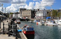 港口阳光明媚，风景如画，有船只和历史建筑