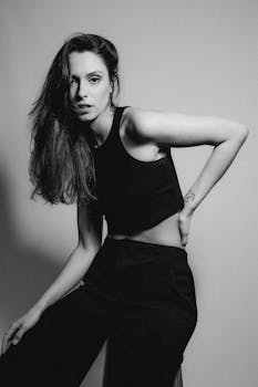 Stylish young woman in a monochrome portrait wearing a tank top and pants.