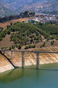 Scenic aerial view of Iznájar Reservoir with a bridge and surrounding landscape, Spain.