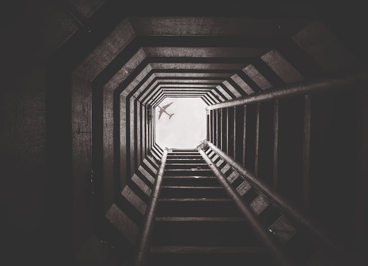 Airplane Flying Over Tunnel With Ladder