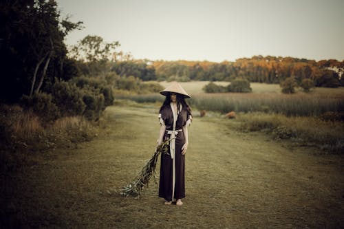 A Person in a Kimono Holding a Bunch of Leaves