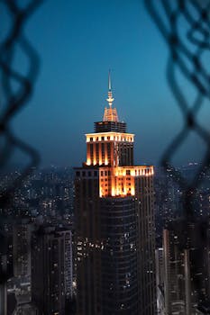 A striking view of a lit skyscraper in a bustling cityscape at night.
